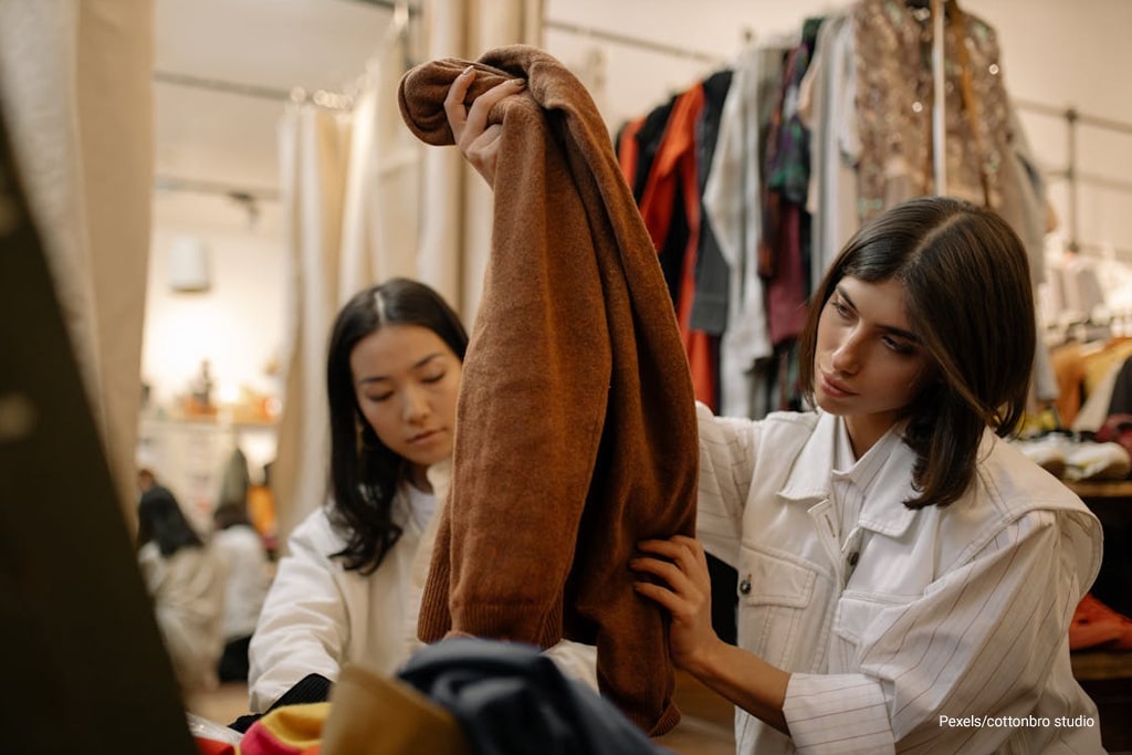 two woman buying clothes at thrift shop store