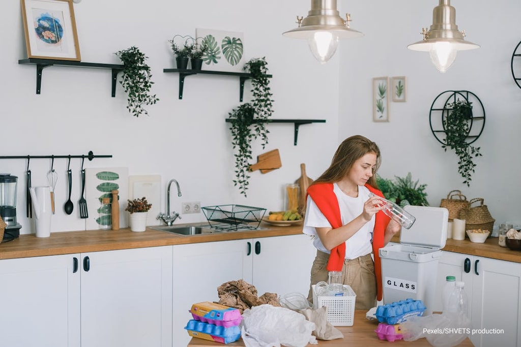 woman throwing bottle to the garbage bin